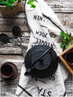 Siyah çaydanlık, yeşil çay, nane ve kaşık ile iki kase