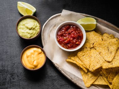 Meksika cips cips mezarda salsa sos, peynir sosu ve Guakamole sos ve kireç dilim