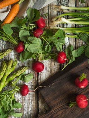 Eski bir ahşap zemin üzerine ahşap karanlık gemide bahar sebzeler. 