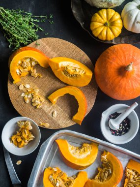 Turuncu taze kabak baharat ve otlar ile yemek. bir fırın tepsisine ve ahşap tahta üzerinde kabak dilimler kesin. Üstten Görünüm