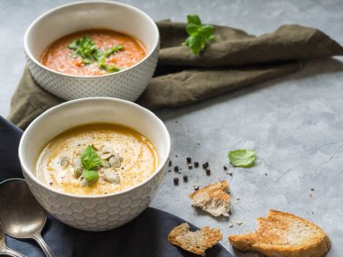 Ev yapımı sonbahar Çorbalar - kabak krem-çorba ve domates çorbası keten bir havlu üzerinde gri bir arka plan üzerinde krem. Üstten görünüm