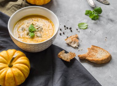 Gri bir arka plan üzerinde kremalı balkabağı krem çorbası. Mevsimlik yemekler. Sağlıklı Vejetaryen yiyecekler. açık alan
