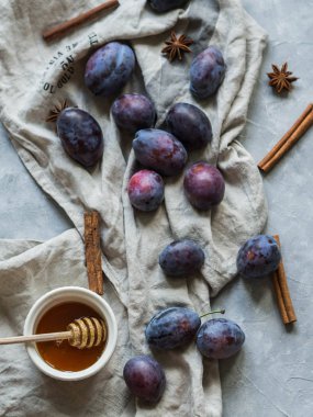 Mavi Erik, baharat ve gri bir arka plan üzerine bir havlu üzerinde tatlım. Meyve arka plan. Üstten görünüm