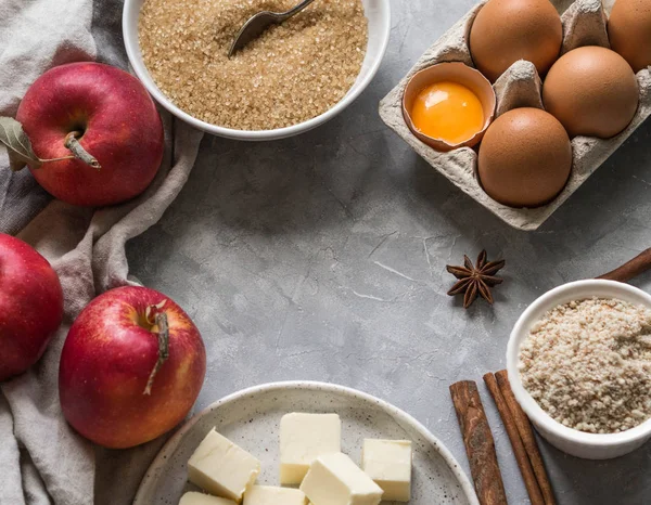 bir dizi için bir çerçeve gri bir arka plan üzerinde şeklinde elmalı turta malzemeler. Elma, şeker kamışı, badem unu, baharat, yumurta ve tereyağı. gıda kavramı.