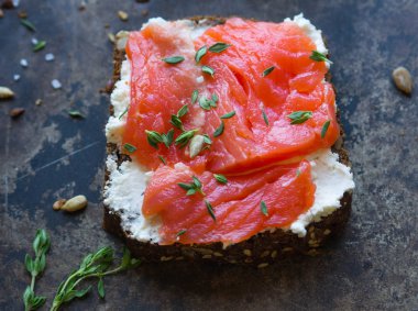 Krem peynir, somon ve eski bir metal zemin üzerine kekik ile sandviç. Üstten görünüm