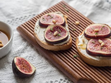 İki beyaz peçeteye gemide fındık ricotta ve incir tatlım, kekik ve sedir kızartır