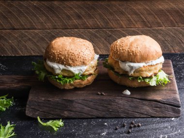 İki ev yapımı balık burger ahşap bir kara tahta üzerinde