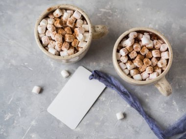 İki bardak sıcak çikolata ve şekerleme ve vintage bir şerit gri bir arka plan üzerinde beyaz bir etiketle