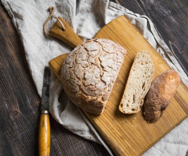 Ahşap bir masa üzerinde bir gemide somun ekmek dilimlenmiş
