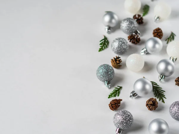 Silber-weiß glitzernde Weihnachtskugel, Tannenzapfen und Weihnachtsbaumzweig lagen flach. Kopierraum — Stockfoto