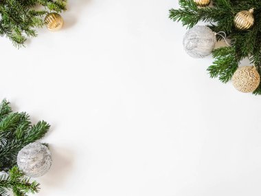 Beyaz arka planda Noel topları ve köknar dalları olan yaratıcı bir Noel çerçevesi vardı. Üst görünüm.