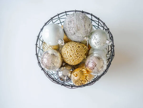Uma cesta de vime de metal com várias bolas de Natal de ouro e prata. Foco seletivo — Fotografia de Stock