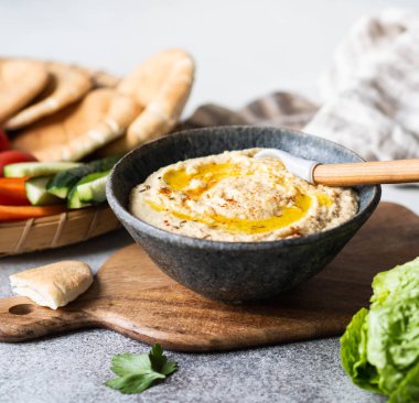 Ev yapımı geleneksel humus sosu taze sebze, pide ve otlarla servis edilir..