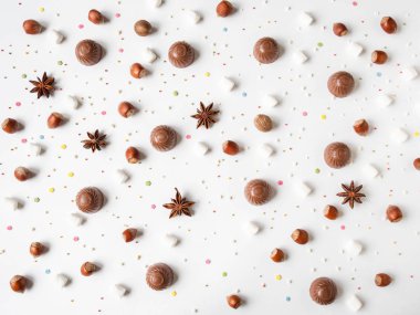 Beyaz arka planda çikolata, baharat, marşmelov ve pasta karışımı tatlı bir pasta kompozisyonu..