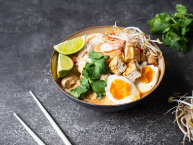 Malezya eriştesi laksa çorbası, tavuk, karides ve soya peyniri.