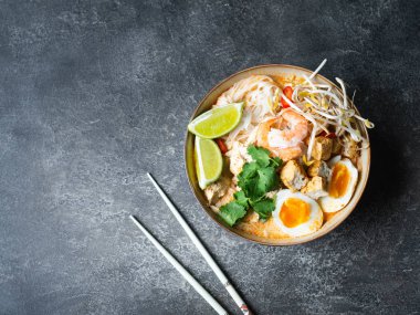 Malezya eriştesi laksa çorbası, tavuk, karides ve soya peyniri.