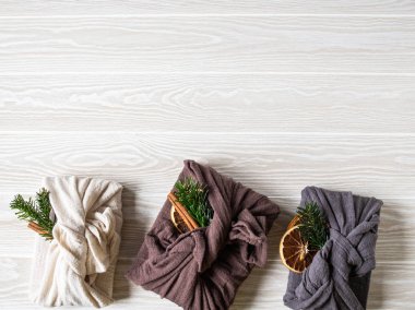 Çevre dostu kumaş yeniden kullanılabilir hediye paketleri köknar brunch, tarçın çubuğu ve kuru portakal dilimi. Noel yeniden kullanılabilir hediye paketleme alternatifi. Sıfır atık. Boşluğu kopyala