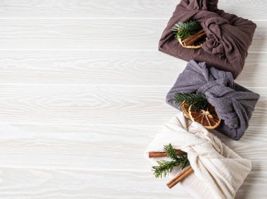 Çevre dostu kumaş yeniden kullanılabilir hediye paketleri köknar brunch, tarçın çubuğu ve kuru portakal dilimi. Noel yeniden kullanılabilir hediye paketleme alternatifi. Sıfır atık. Boşluğu kopyala