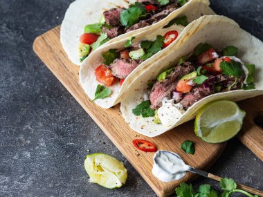 Sebzeli tortilla ve biftek dilimleri. Avokadolar, domatesler, kırmızı soğanlar ve kişniş ve limon suyu ile tortilla. Meksika yemeği.