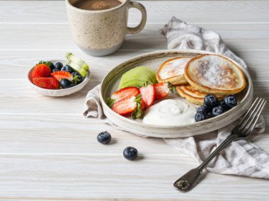 Lezzetli kahvaltı - börek krep, üzerine pudra şekeri serpiştirilmiş meyve ve böğürtlen ve ekşi krema