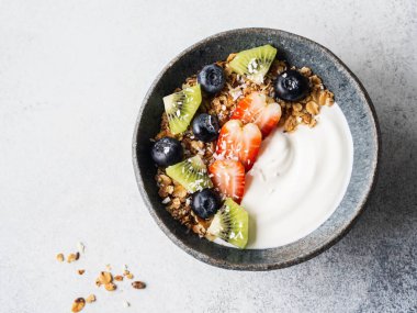 Lezzetli kahvaltı - yoğurtlu tahıl gevreği, masada meyve ve böğürtlen. Üst görünüm