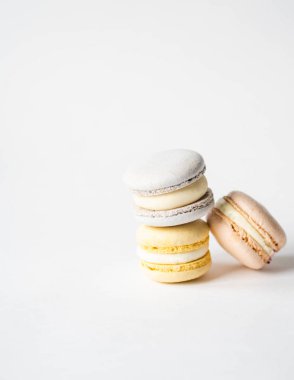 Beyaz arka planda üç taze Fransız pastel makaronu yığını. Boşluğu kopyala