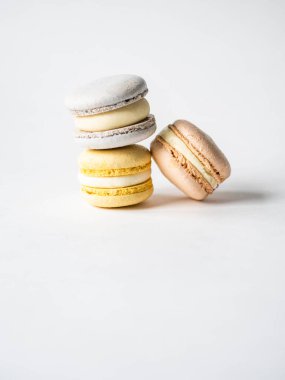 Beyaz arka planda üç taze Fransız pastel makaronu yığını. Boşluğu kopyala