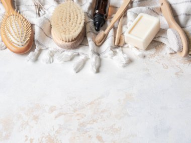 Farklı vücut fırçaları, beyaz pamuk havlu, sünger taşı, bambu diş fırçası, aromatik yağ ve bir kalıp sabun. Sıfır atık. Çevre dostu banyo seti. Üst görünüm