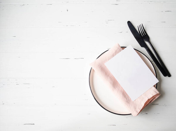 Сельский стол с тарелкой, розовой салфеткой, карточкой и бытовой техникой на белом деревянном столе. Вид сверху
.