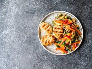 Hindi pirzolası ızgarası, sebze kızartması, masada koyu arkaplanda bir tabak. Üst görünüm