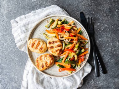 Hindi pirzolası ızgarası, sebze kızartması, masada koyu arkaplanda bir tabak. Üst görünüm