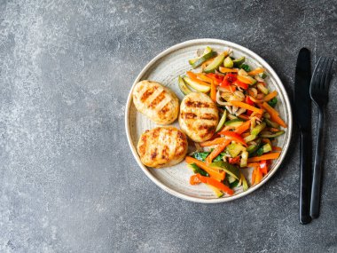 Hindi pirzolası ızgarası, sebze kızartması, masada koyu arkaplanda bir tabak. Üst görünüm
