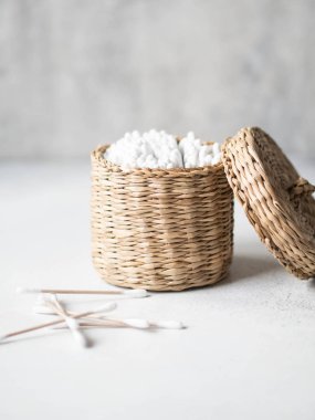 Gri arka planda sepetin içinde eko pamuk tomurcukları