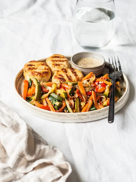 Turkey cutlets grill, sauce and vegetables steer fry on a plate on the table