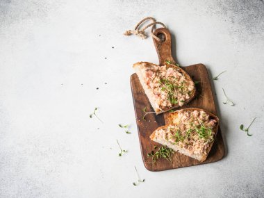 Sağlıklı tostlar somon ezmesi ve taze yeşil lahanalar üzerinde mayasız ekmek gri arka planda tahta kesme tahtası. Boşluğu kopyala