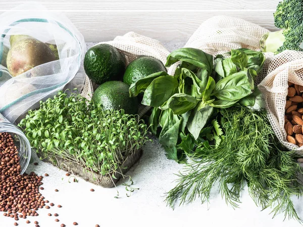 Healthy vegetarian ingredients for cooking. Various clean wholesome vegetables, herbs, fruits in woven bags. Products from the market without plastic. — Stock Photo, Image