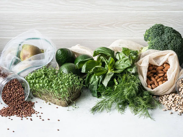 Healthy vegetarian ingredients for cooking. Various clean wholesome vegetables, herbs, fruits in woven bags. Products from the market without plastic. — Stock Photo, Image