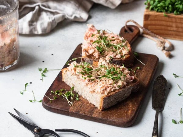 Toasts sains avec pâté de saumon et choux verts frais sur pain sans levure sur planche à découper sur fond gris. Espace de copie — Photo