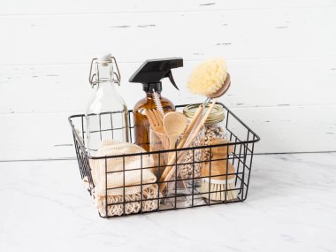 Sıfır atık. Çevre dostu mutfak seti. Yiyecek, fırça, ahşap eşyalar, çantalar, şişe ve kavanoz siyah metal bir sepetin içinde. Boşluğu kopyala