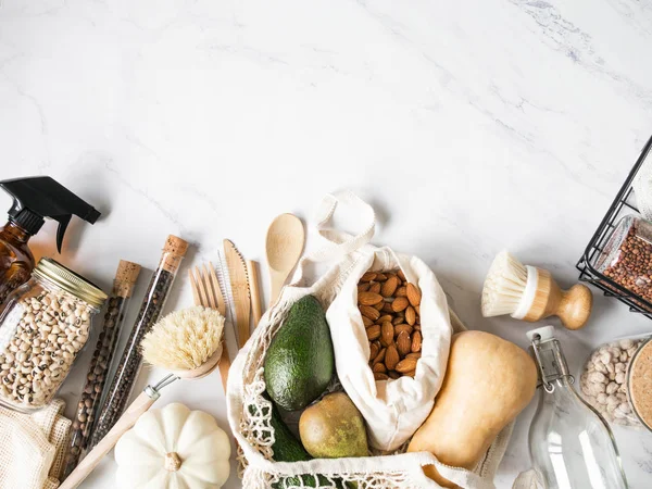 Zero waste concept. Flat lay eco-friendly kitchen set. Food, brushes, wood appliances, bags, bottle and jar, spices in glass tubes on a marble background. Top view. copy space — Stock Photo, Image