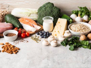 Sağlıklı ham ham maddeler - meyve, sebze, süt ürünleri, yumurta, baklagil, diyet eti ve balık, fındık ve tohum masada. Uzayı kopyala Dengeli sağlıklı gıda konsepti