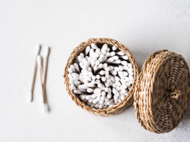 Gri arka planda sepetin içinde eko pamuklar. Üst görünüm