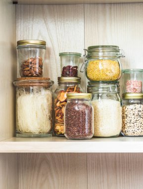 Mutfaktaki rafta çeşitli tahıl ve tohumlar var.