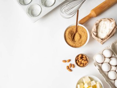 Çeşitli pişirme malzemeleri - un, yumurta, şeker, tereyağı, fındık, mutfak aletleri ve beyaz arka planda kek pişirme kabı. Üst Manzara. Boşluğu kopyala
