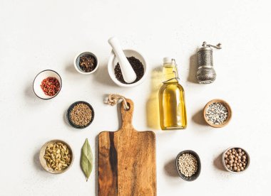 Ahşap kesme tahtası, mutfak metni için maket, arka planda küçük kaselerde yağ ve baharat bulunan cam şişe. Üst görünüm