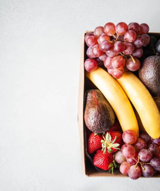 Taze meyveli büyük bir karton kutu. Süpermarketlerden gelen ürünlerin eve teslimi kavramı.