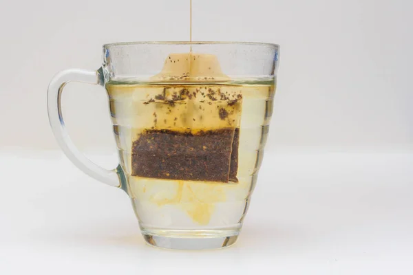 Чайный пакетик, погруженный в стакан горячей воды — стоковое фото
