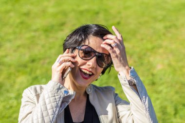 Gülümseyen mutlu kadın telefonda konuşuyor.