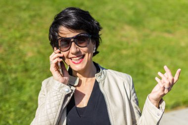 Gülümseyen mutlu kadın telefonda konuşuyor.