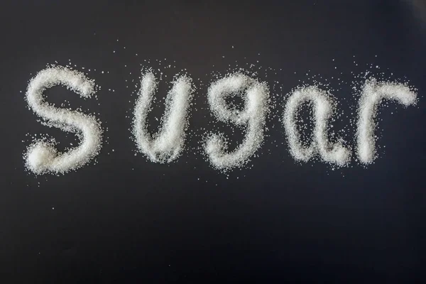砂糖は白い砂糖の穀物とスペルアウト — ストック写真